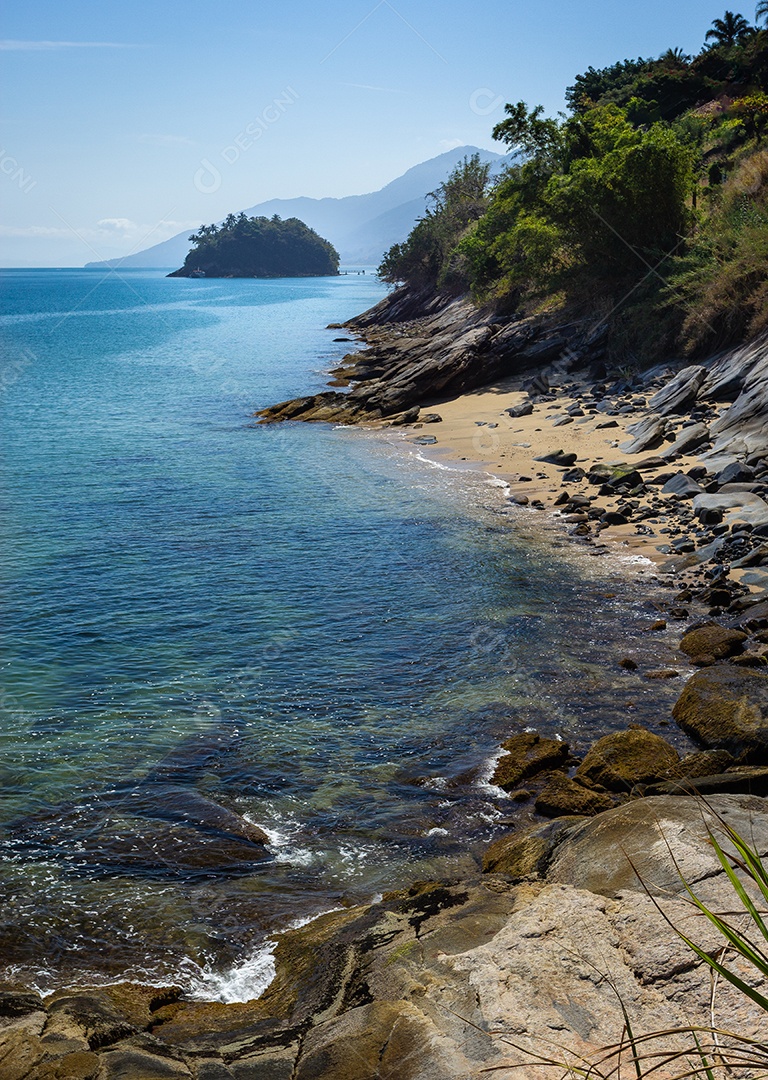 A imagem mostra uma paisagem costeira que se assemelha às praias do Arquipélago de Ilhabela