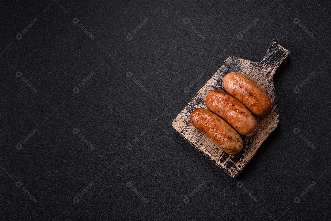 Imagem mostra um prato com salsichas grelhadas ou assadas, acompanhadas de legumes e temperos.