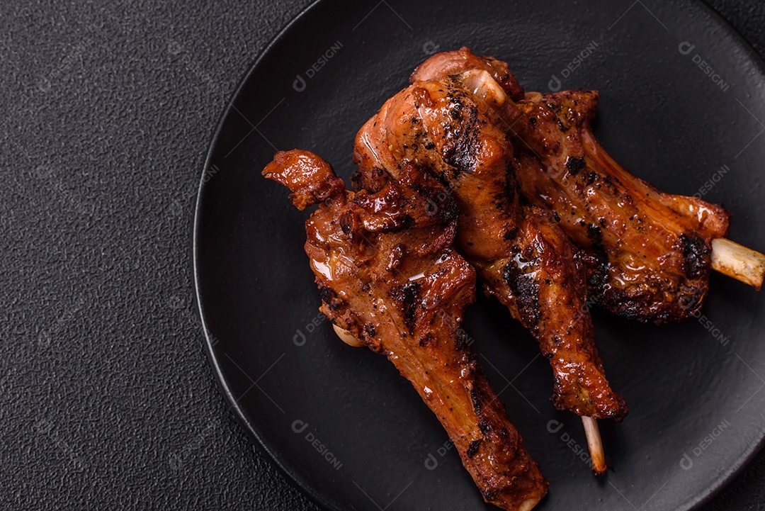 Costelas de porco grelhadas ou assadas, provavelmente com molho barbecue