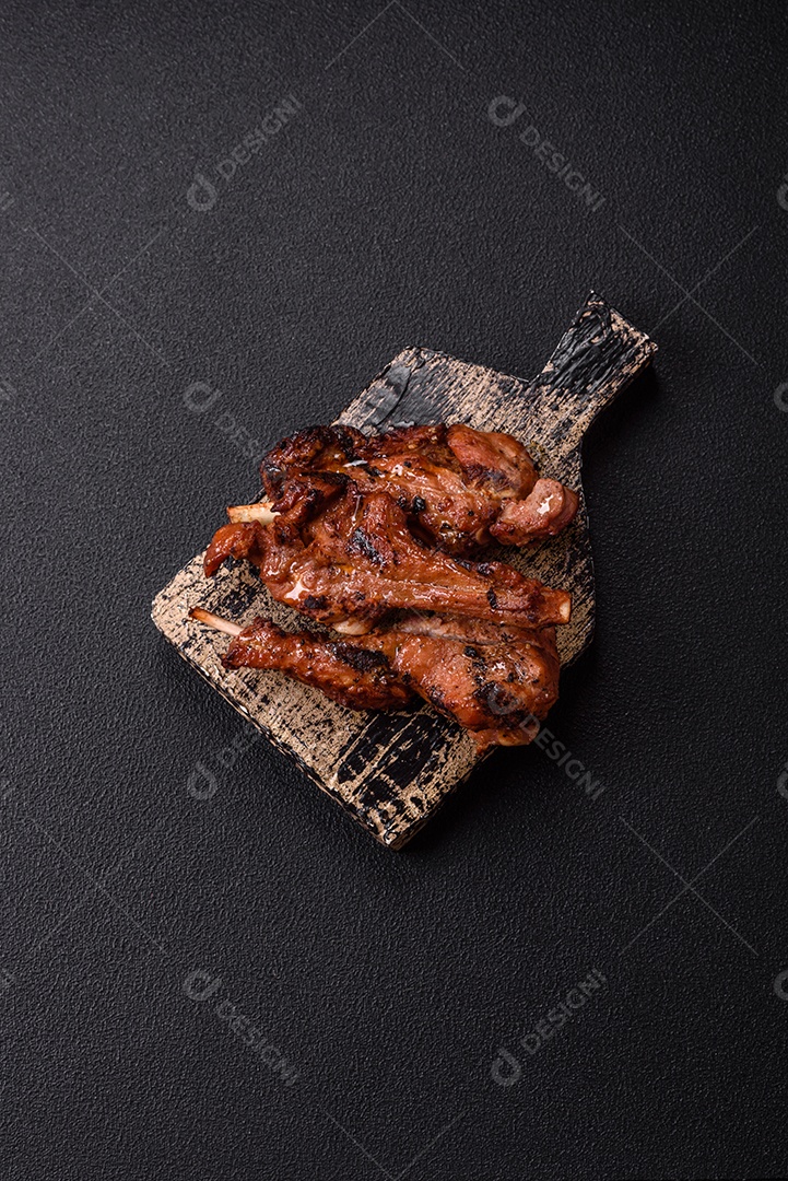 Costelas de porco grelhadas ou assadas, provavelmente com molho barbecue