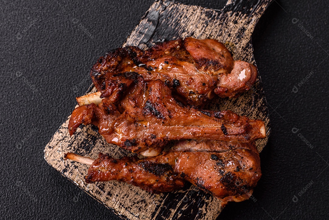 Costelas de porco grelhadas ou assadas, provavelmente com molho barbecue