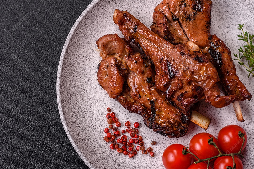 Costelas de porco grelhadas ou assadas, provavelmente com molho barbecue