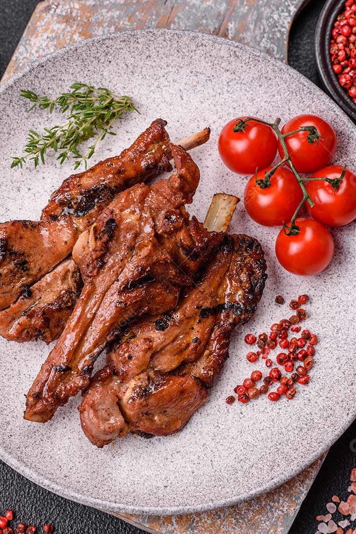 Costelas de porco grelhadas ou assadas, provavelmente com molho barbecue