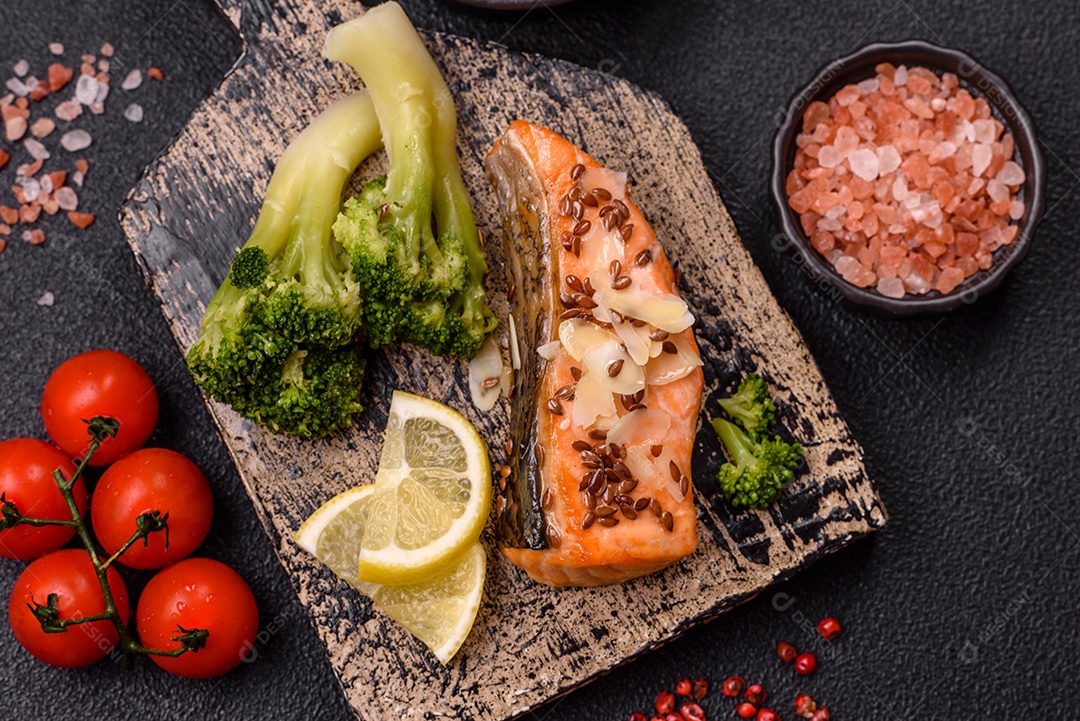 Imagem mostra um prato de salmão grelhado acompanhado de brócolis e arroz com legumes, decorado com uma fatia de limão e tomate