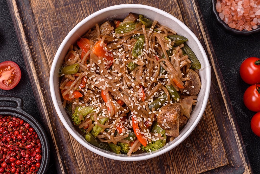 Imagem mostra um prato de noodles asiáticos, possivelmente um tipo de macarrão como Soba ou Udon, servido em uma tigela branca