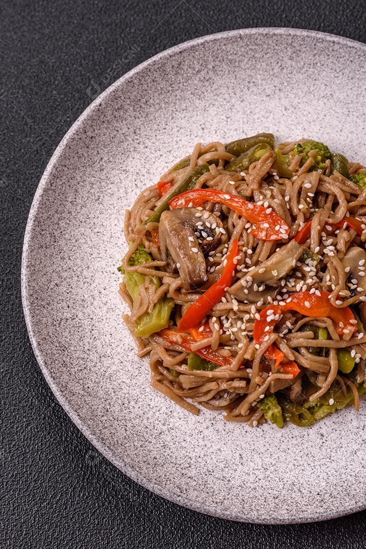 Imagem mostra um prato de noodles asiáticos, possivelmente um tipo de macarrão como Soba ou Udon, servido em uma tigela branca