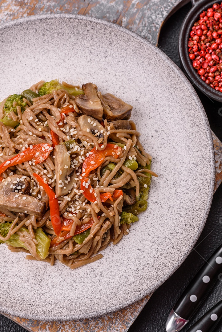 Imagem mostra um prato de noodles asiáticos, possivelmente um tipo de macarrão como Soba ou Udon, servido em uma tigela branca