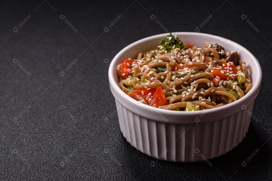 Imagem mostra um prato de noodles asiáticos, possivelmente um tipo de macarrão como Soba ou Udon, servido em uma tigela branca