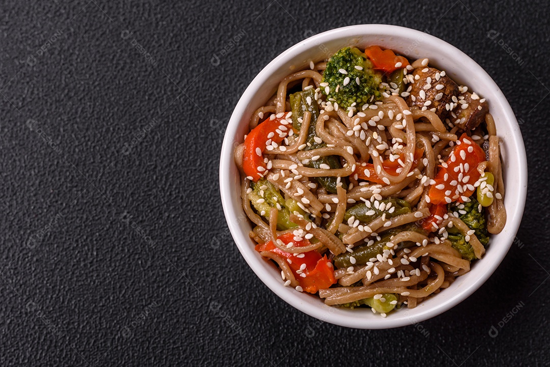 Imagem mostra um prato de noodles asiáticos, possivelmente um tipo de macarrão como Soba ou Udon, servido em uma tigela branca