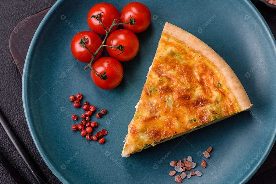 Imagem mostra uma fatia de quiche, acompanhada de tomates-cereja e grãos de pimenta rosa