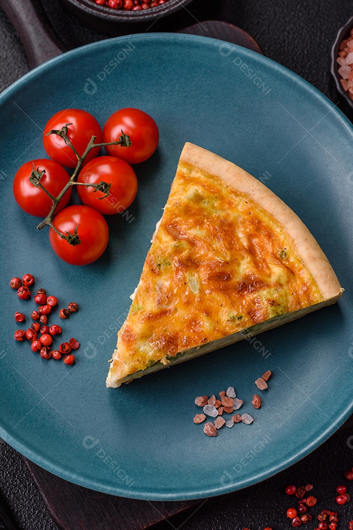Imagem mostra uma fatia de quiche, acompanhada de tomates-cereja e grãos de pimenta rosa