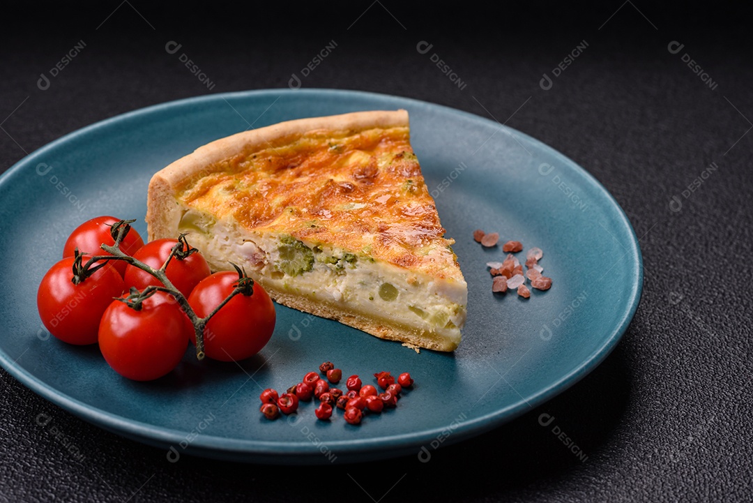 Imagem mostra uma fatia de quiche, acompanhada de tomates-cereja e grãos de pimenta rosa