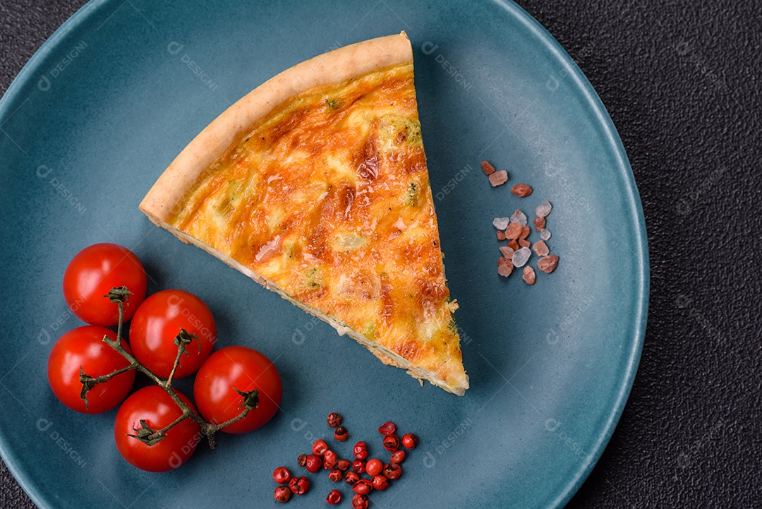 Imagem mostra uma fatia de quiche, acompanhada de tomates-cereja e grãos de pimenta rosa