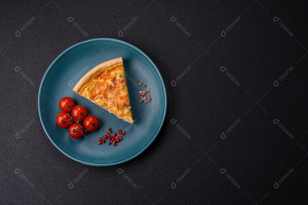 Imagem mostra uma fatia de quiche, acompanhada de tomates-cereja e grãos de pimenta rosa