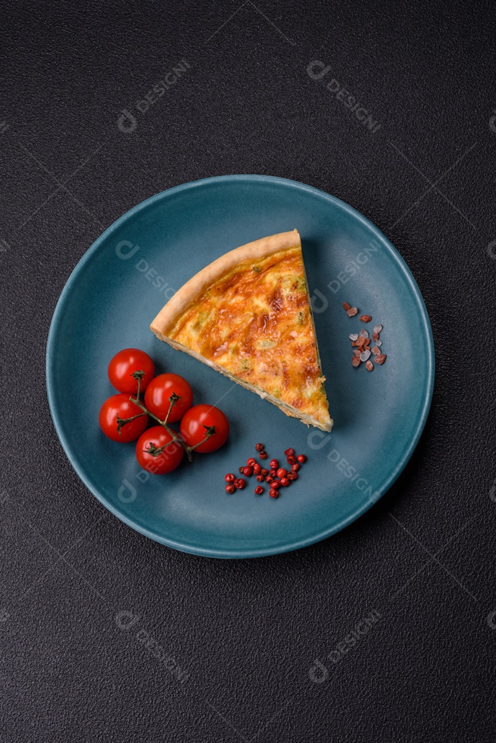 Imagem mostra uma fatia de quiche, acompanhada de tomates-cereja e grãos de pimenta rosa