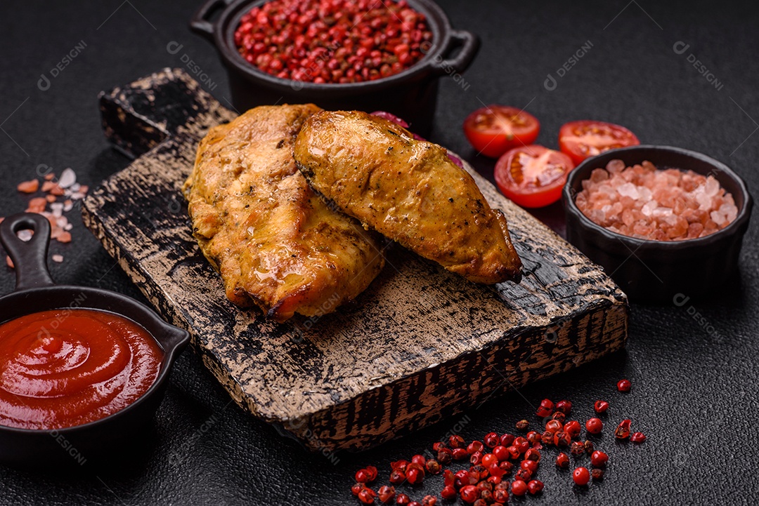 Filés de frango grelhados ou assados, acompanhados de tomates cereja, cebola roxa em rodelas e alguns temperos ou especiarias em grãos e em pó. Há também um molho vermelho em um recipiente separado, que pode ser ketchup ou outro molho à base de tomate