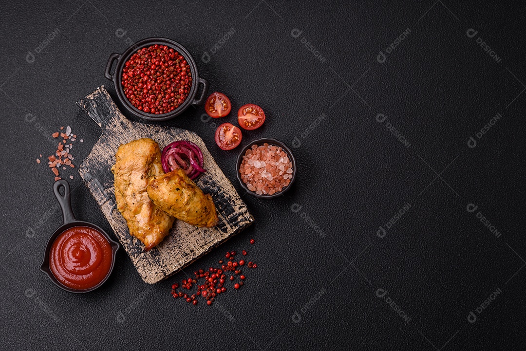 Filés de frango grelhados ou assados, acompanhados de tomates cereja, cebola roxa em rodelas e alguns temperos ou especiarias em grãos e em pó. Há também um molho vermelho em um recipiente separado, que pode ser ketchup ou outro molho à base de tomate