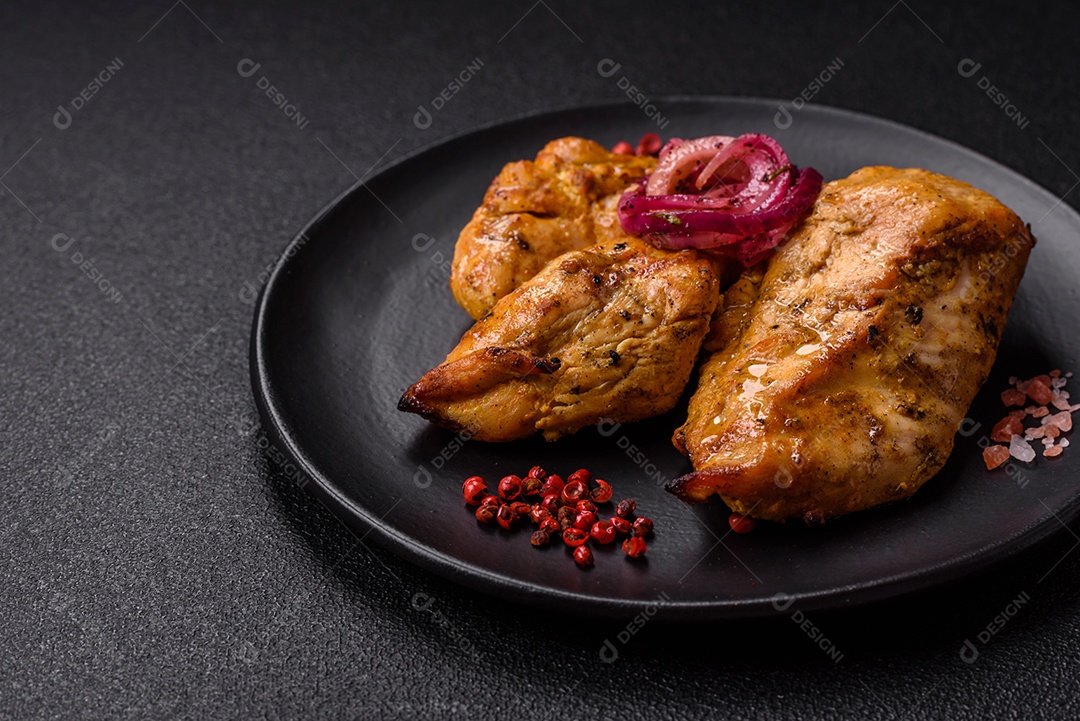 Filés de frango grelhados ou assados, acompanhados de tomates cereja, cebola roxa em rodelas e alguns temperos ou especiarias em grãos e em pó. Há também um molho vermelho em um recipiente separado, que pode ser ketchup ou outro molho à base de tomate