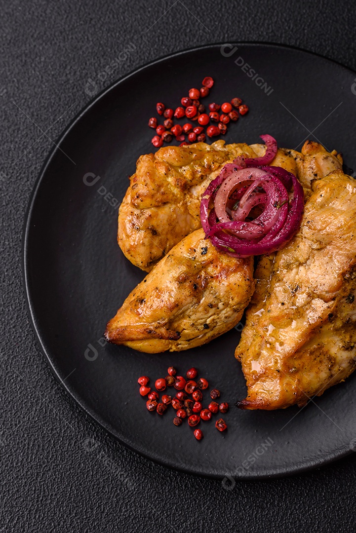 Filés de frango grelhados ou assados, acompanhados de tomates cereja, cebola roxa em rodelas e alguns temperos ou especiarias em grãos e em pó. Há também um molho vermelho em um recipiente separado, que pode ser ketchup ou outro molho à base de tomate