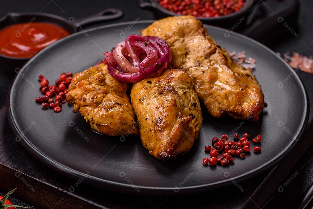 Filés de frango grelhados ou assados, acompanhados de tomates cereja, cebola roxa em rodelas e alguns temperos ou especiarias em grãos e em pó. Há também um molho vermelho em um recipiente separado, que pode ser ketchup ou outro molho à base de tomate