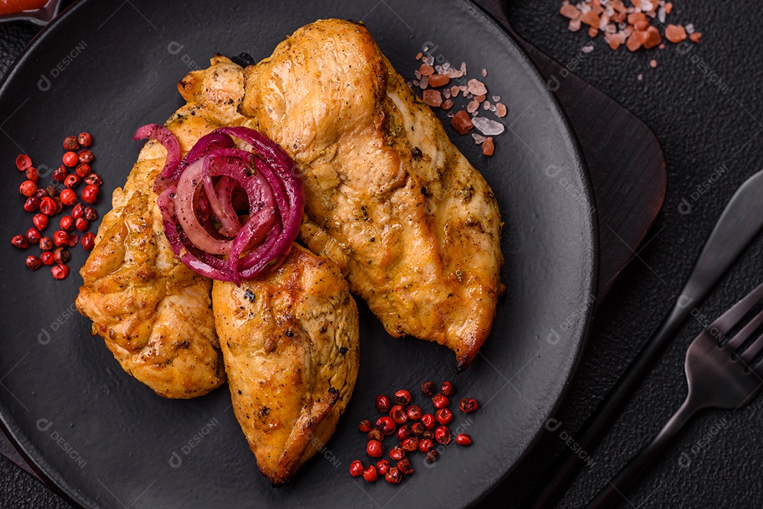 Filés de frango grelhados ou assados, acompanhados de tomates cereja, cebola roxa em rodelas e alguns temperos ou especiarias em grãos e em pó. Há também um molho vermelho em um recipiente separado, que pode ser ketchup ou outro molho à base de tomate