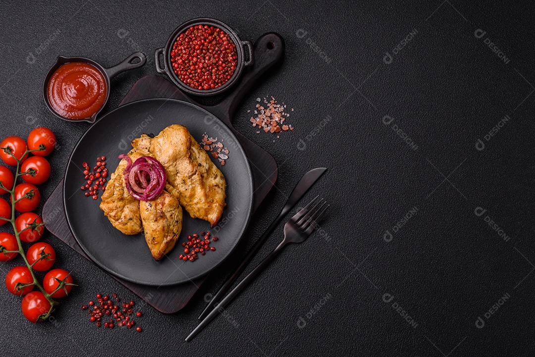 Filés de frango grelhados ou assados, acompanhados de tomates cereja, cebola roxa em rodelas e alguns temperos ou especiarias em grãos e em pó. Há também um molho vermelho em um recipiente separado, que pode ser ketchup ou outro molho à base de tomate