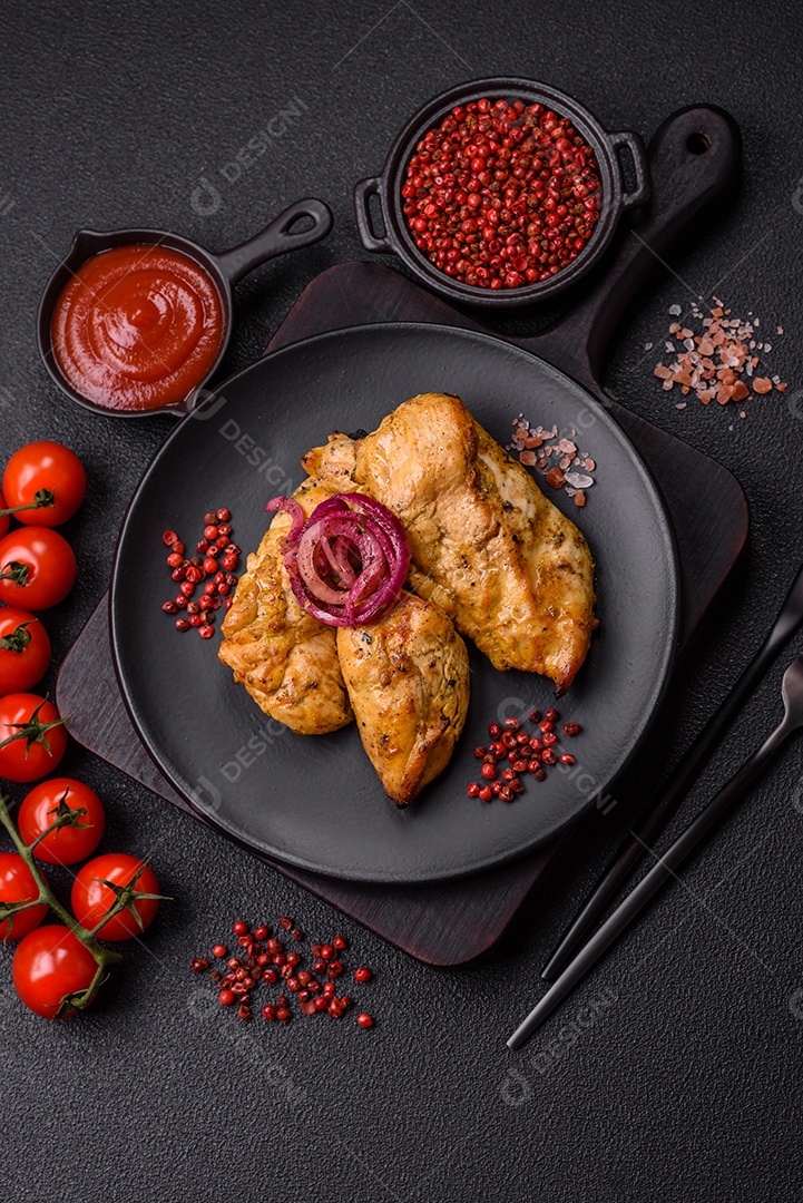 Filés de frango grelhados ou assados, acompanhados de tomates cereja, cebola roxa em rodelas e alguns temperos ou especiarias em grãos e em pó. Há também um molho vermelho em um recipiente separado, que pode ser ketchup ou outro molho à base de tomate