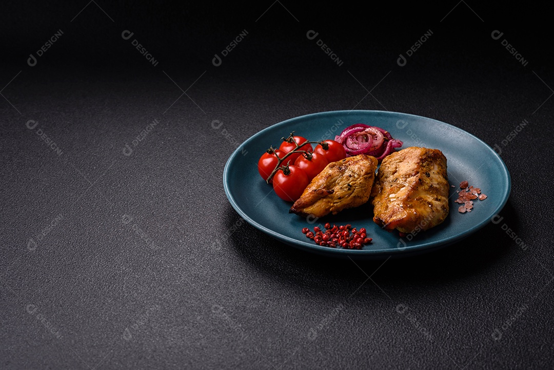 Filés de frango grelhados ou assados, acompanhados de tomates cereja, cebola roxa em rodelas e alguns temperos ou especiarias em grãos e em pó. Há também um molho vermelho em um recipiente separado, que pode ser ketchup ou outro molho à base de tomate