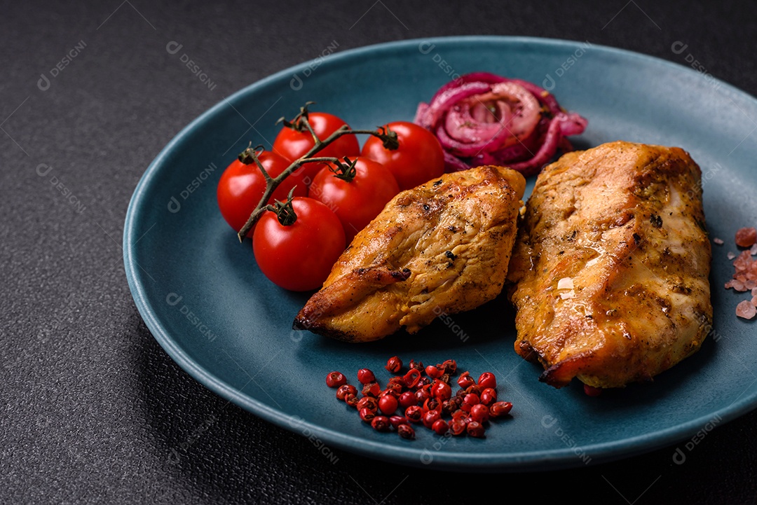 Filés de frango grelhados ou assados, acompanhados de tomates cereja, cebola roxa em rodelas e alguns temperos ou especiarias em grãos e em pó. Há também um molho vermelho em um recipiente separado, que pode ser ketchup ou outro molho à base de tomate
