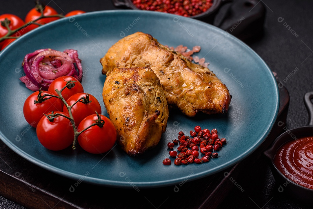 Filés de frango grelhados ou assados, acompanhados de tomates cereja, cebola roxa em rodelas e alguns temperos ou especiarias em grãos e em pó. Há também um molho vermelho em um recipiente separado, que pode ser ketchup ou outro molho à base de tomate