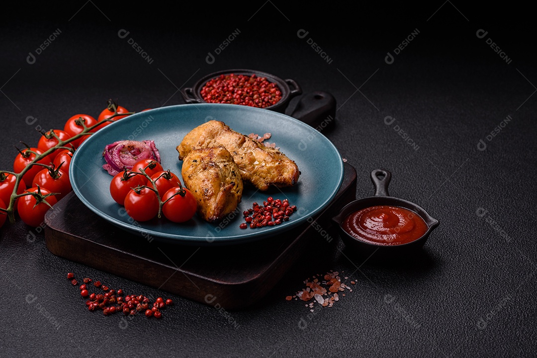 Filés de frango grelhados ou assados, acompanhados de tomates cereja, cebola roxa em rodelas e alguns temperos ou especiarias em grãos e em pó. Há também um molho vermelho em um recipiente separado, que pode ser ketchup ou outro molho à base de tomate