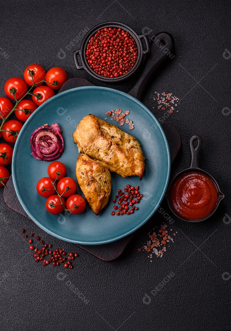 Filés de frango grelhados ou assados, acompanhados de tomates cereja, cebola roxa em rodelas e alguns temperos ou especiarias em grãos e em pó. Há também um molho vermelho em um recipiente separado, que pode ser ketchup ou outro molho à base de tomate