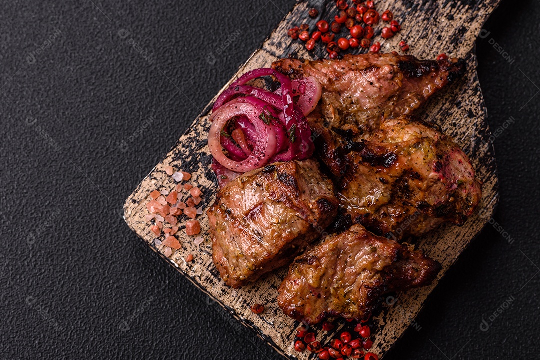Prato com pedaços de carne grelhada, que se assemelham a fígado bovino, acompanhados de molho