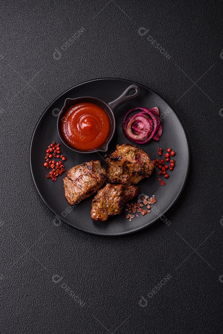 Prato com pedaços de carne grelhada, que se assemelham a fígado bovino, acompanhados de molho