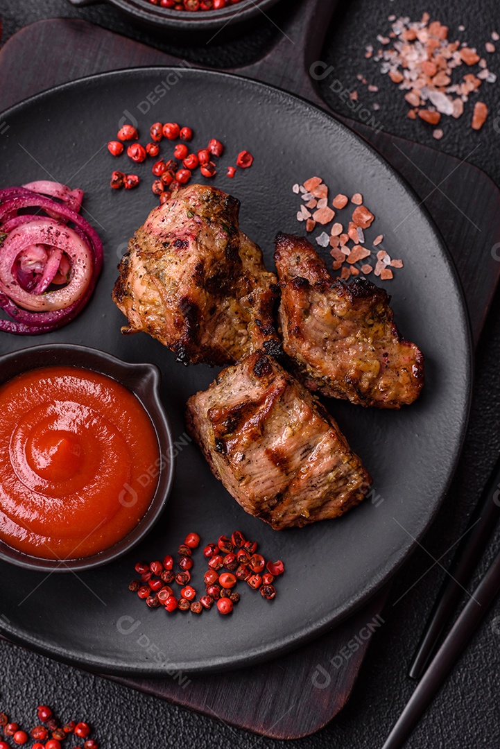Prato com pedaços de carne grelhada, que se assemelham a fígado bovino, acompanhados de molho