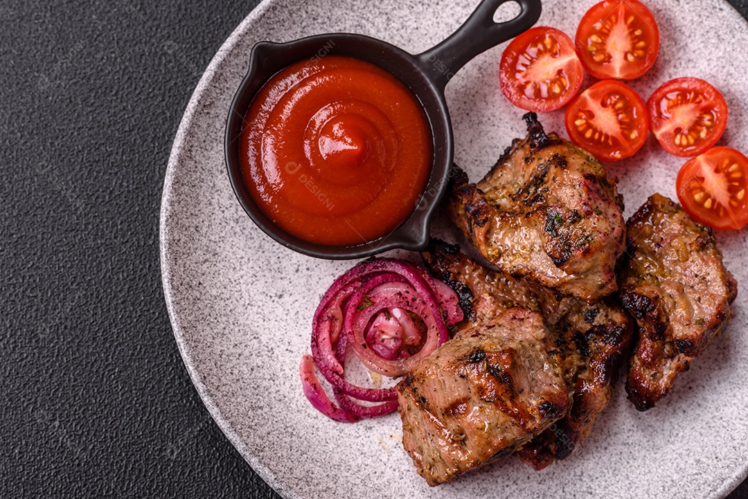 Prato com pedaços de carne grelhada, que se assemelham a fígado bovino, acompanhados de molho