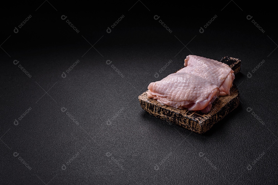 Sobrecoxas de frango cruas, prontas para serem preparadas. A sobrecoxa