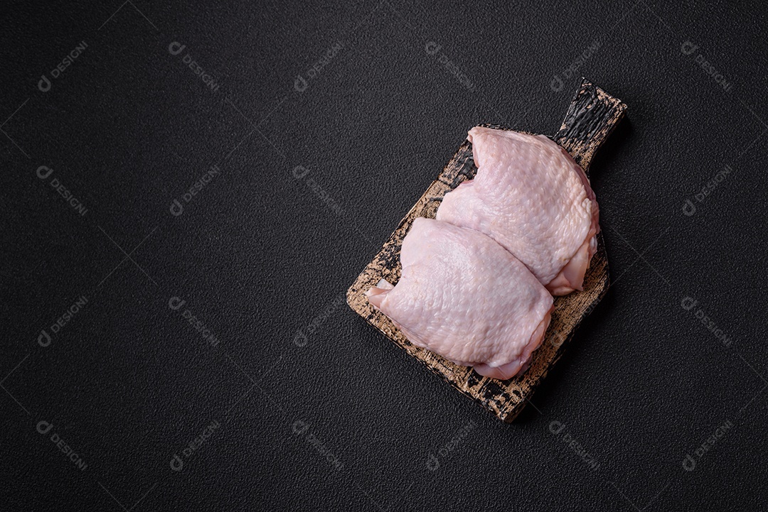 Sobrecoxas de frango cruas, prontas para serem preparadas. A sobrecoxa