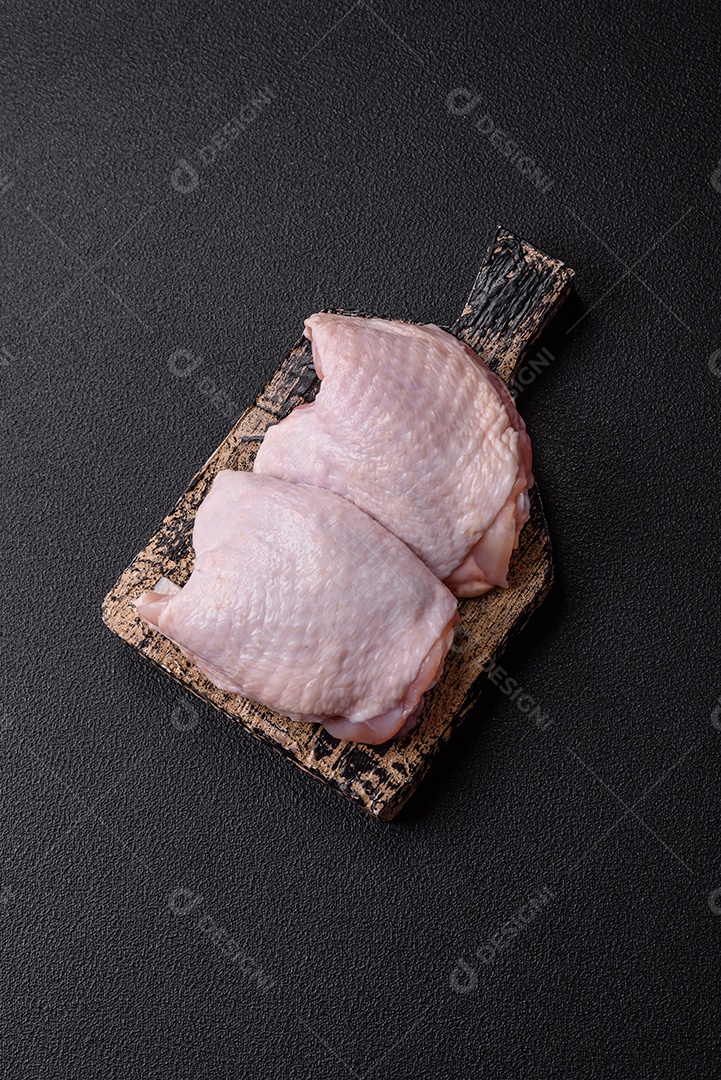 Sobrecoxas de frango cruas, prontas para serem preparadas. A sobrecoxa