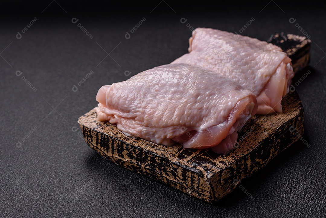 Sobrecoxas de frango cruas, prontas para serem preparadas. A sobrecoxa