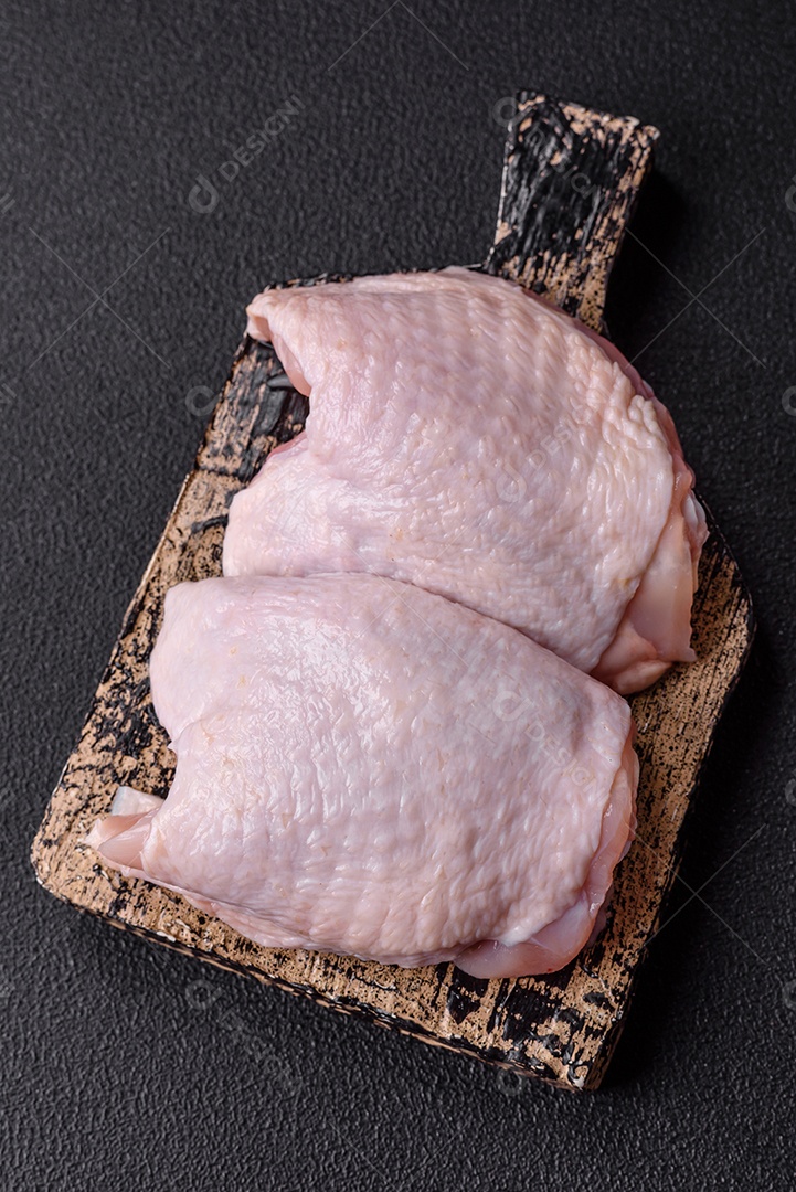 Sobrecoxas de frango cruas, prontas para serem preparadas. A sobrecoxa