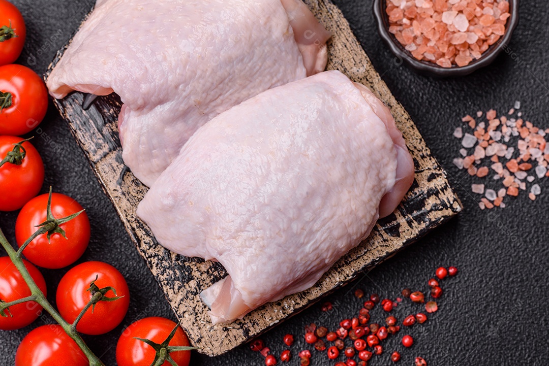 Sobrecoxas de frango cruas, prontas para serem preparadas. A sobrecoxa