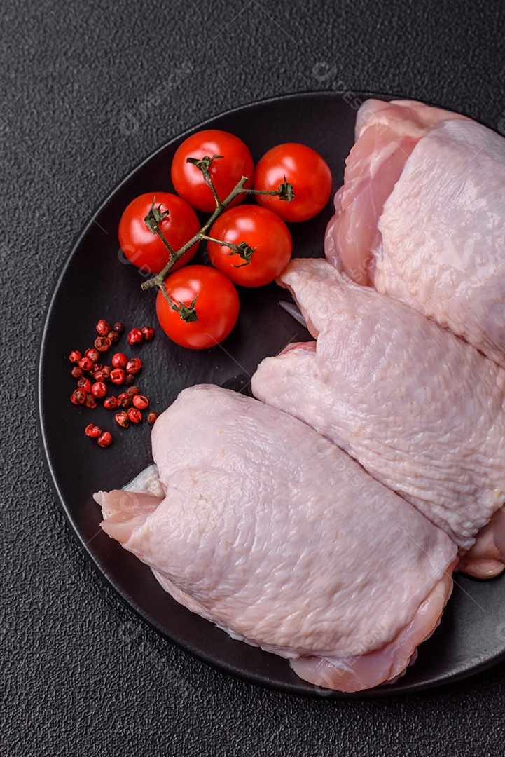 Sobrecoxas de frango cruas, prontas para serem preparadas. A sobrecoxa