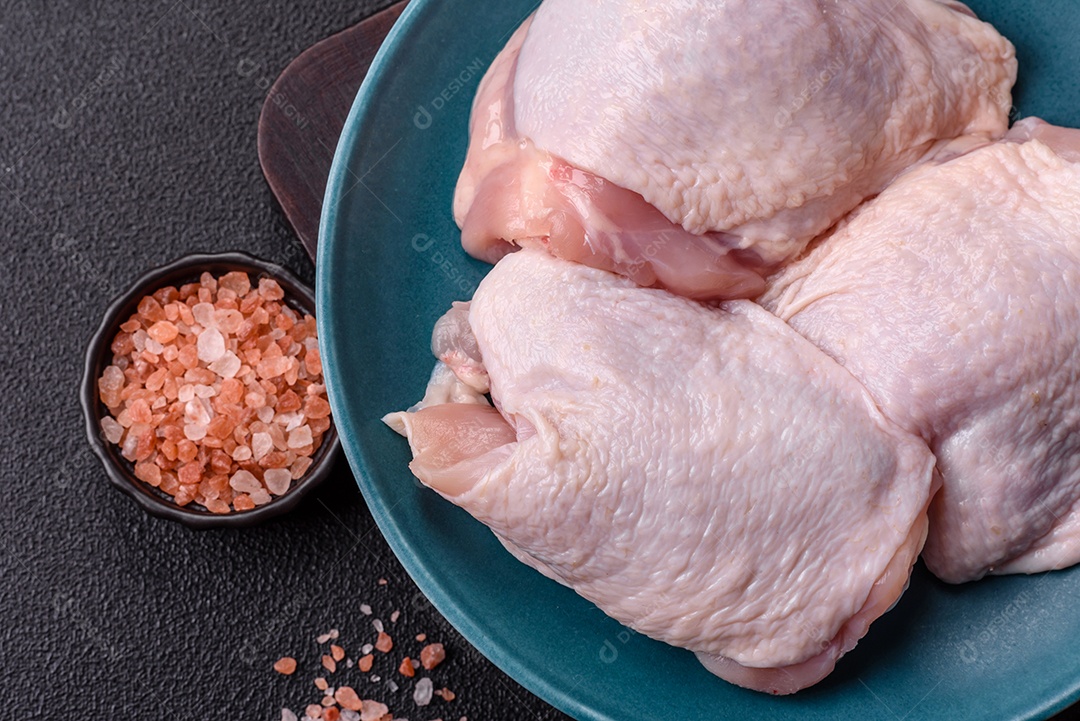 Sobrecoxas de frango cruas, prontas para serem preparadas. A sobrecoxa