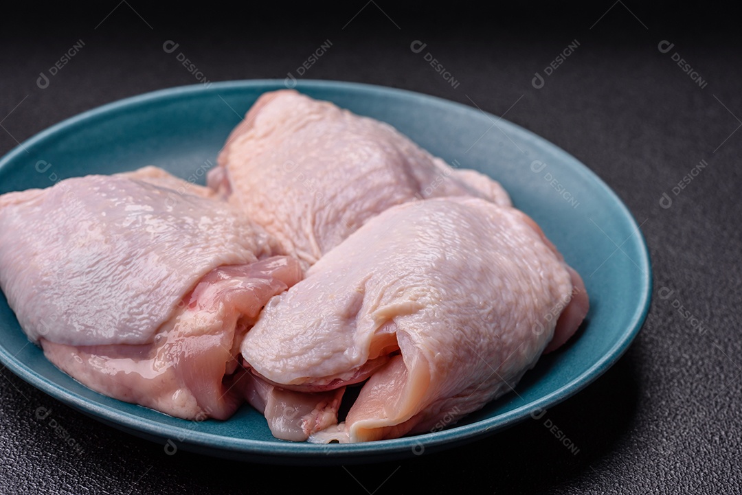 Sobrecoxas de frango cruas, prontas para serem preparadas. A sobrecoxa