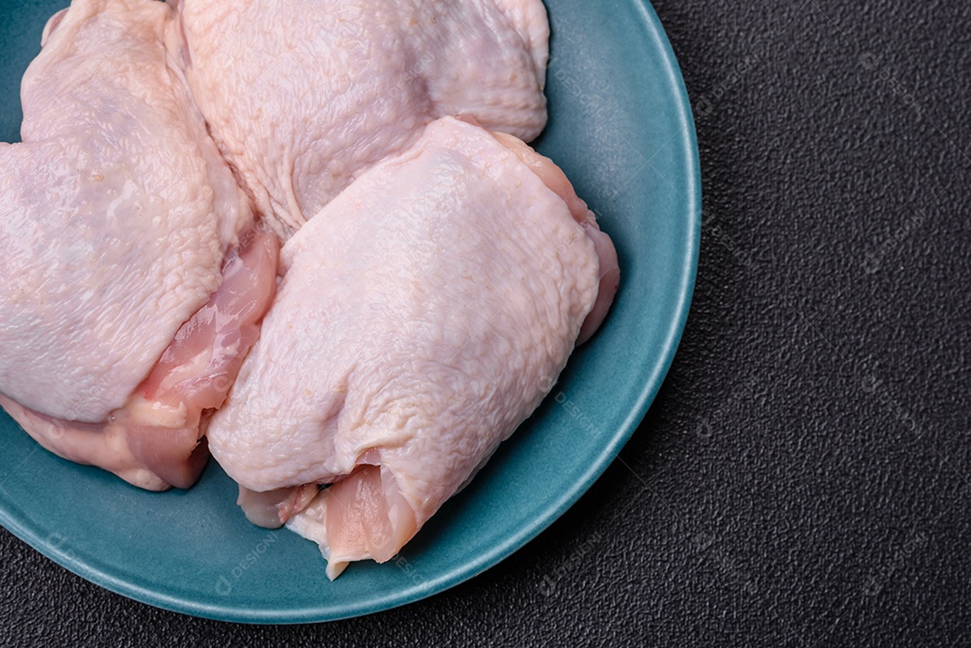 Sobrecoxas de frango cruas, prontas para serem preparadas. A sobrecoxa