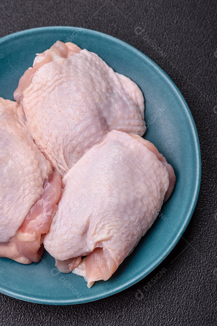 Sobrecoxas de frango cruas, prontas para serem preparadas. A sobrecoxa
