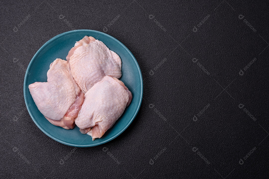 Sobrecoxas de frango cruas, prontas para serem preparadas. A sobrecoxa