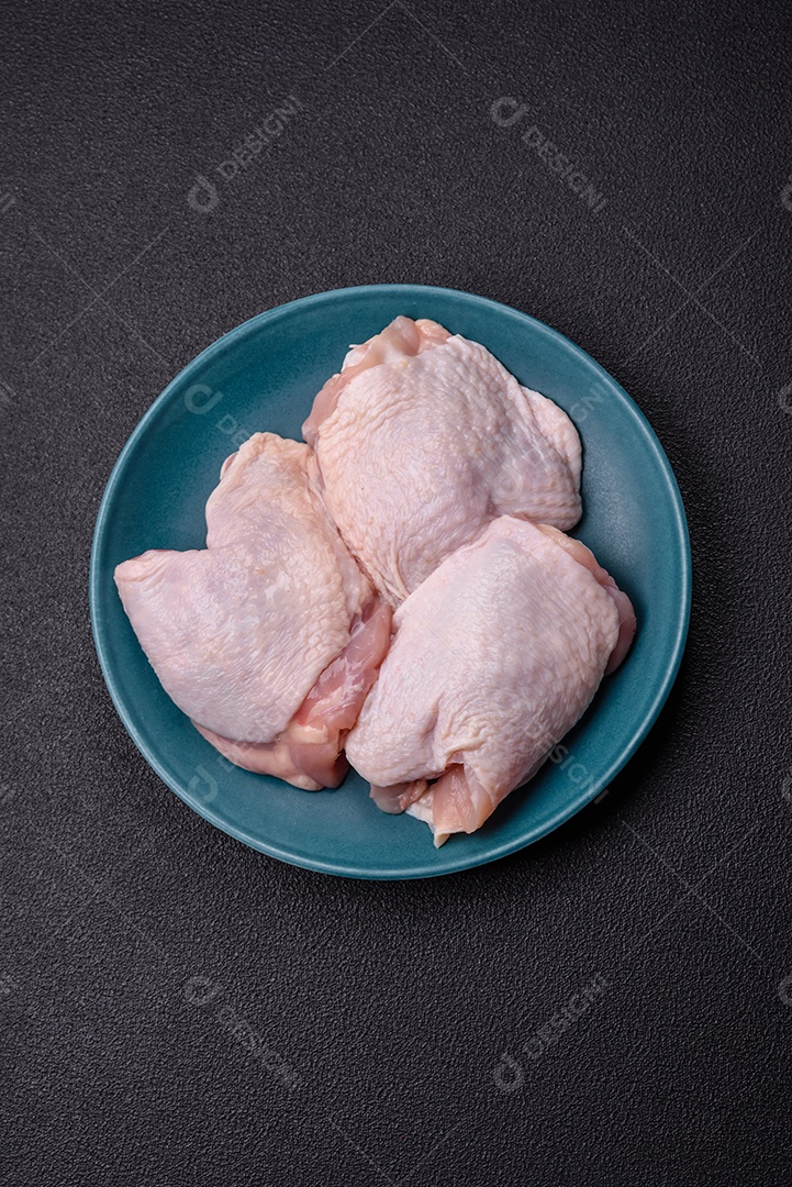 Sobrecoxas de frango cruas, prontas para serem preparadas. A sobrecoxa