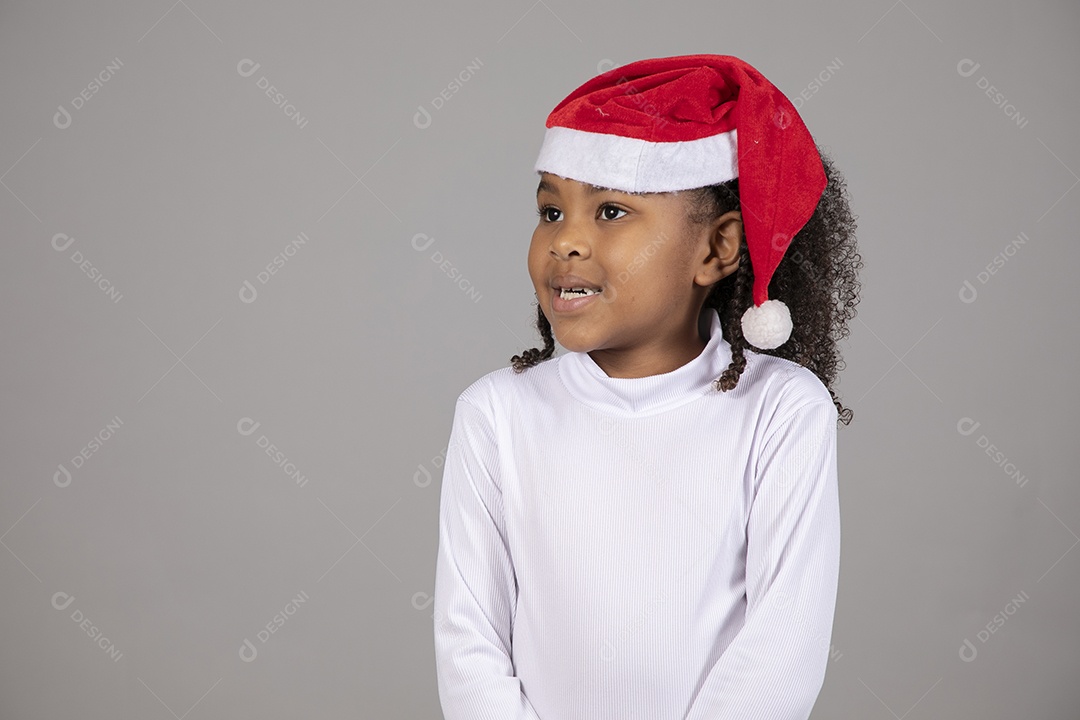 Linda garotinha sorridente usando roupa do papai Noel celebrando natal